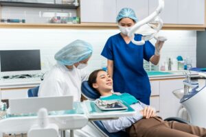 Caucasian dentist examine tooth for young girl at dental health clinic.