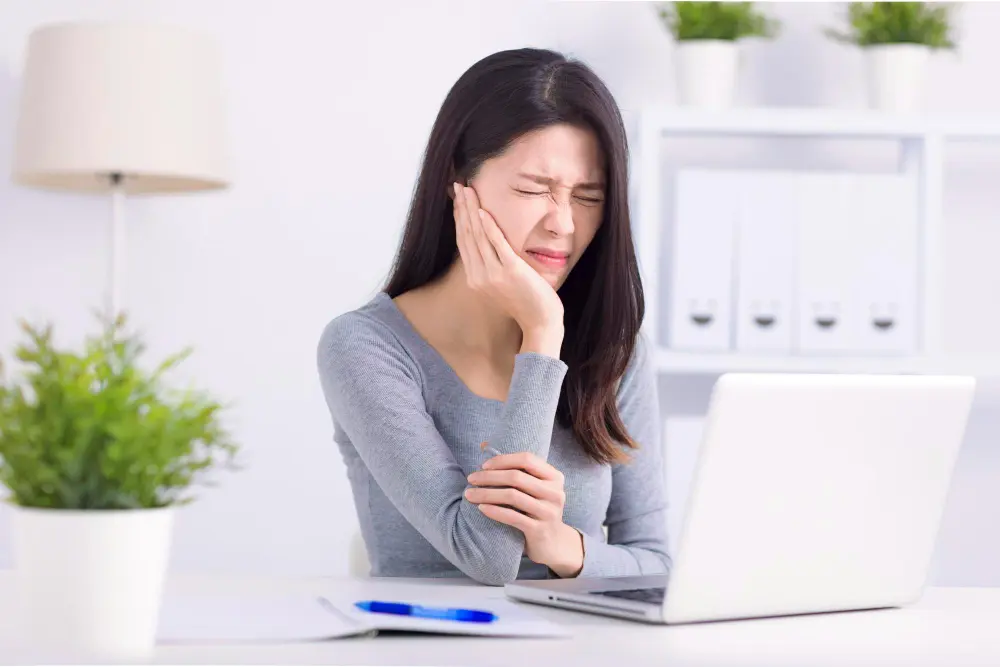 ผู้หญิงมีอาการปวดฟัน ต้องมาใช้บริการอุดฟันผุ ราคาไม่แพง